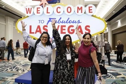 IMEX America attendees pose in front of a Welcome to Las Vegas sign. image courtesy of IMEX