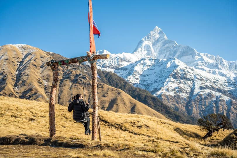 照片：Sudip Shrestha，来自 Pexels | 一位游客在 Machhapuchhre 的背景下荡秋千 | 尼泊尔著名徒步旅行公司征收新的游客费