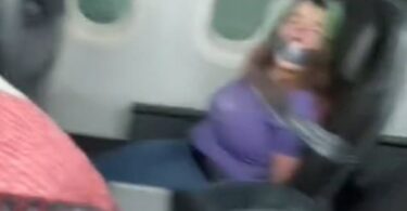 American Airlines авиакомпаниясынын жүргүнчүсү орто жолдогу эшигин ачууга аракет кылып, стюардессаны тиштеп, отурган жерине скотч менен жабыштырылган