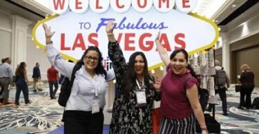 IMEX America iştirakçıları Las Vegasa xoş gəlmisiniz işarəsi qarşısında poza verirlər. şəkil IMEX | izni ilə eTurboNews | eTN