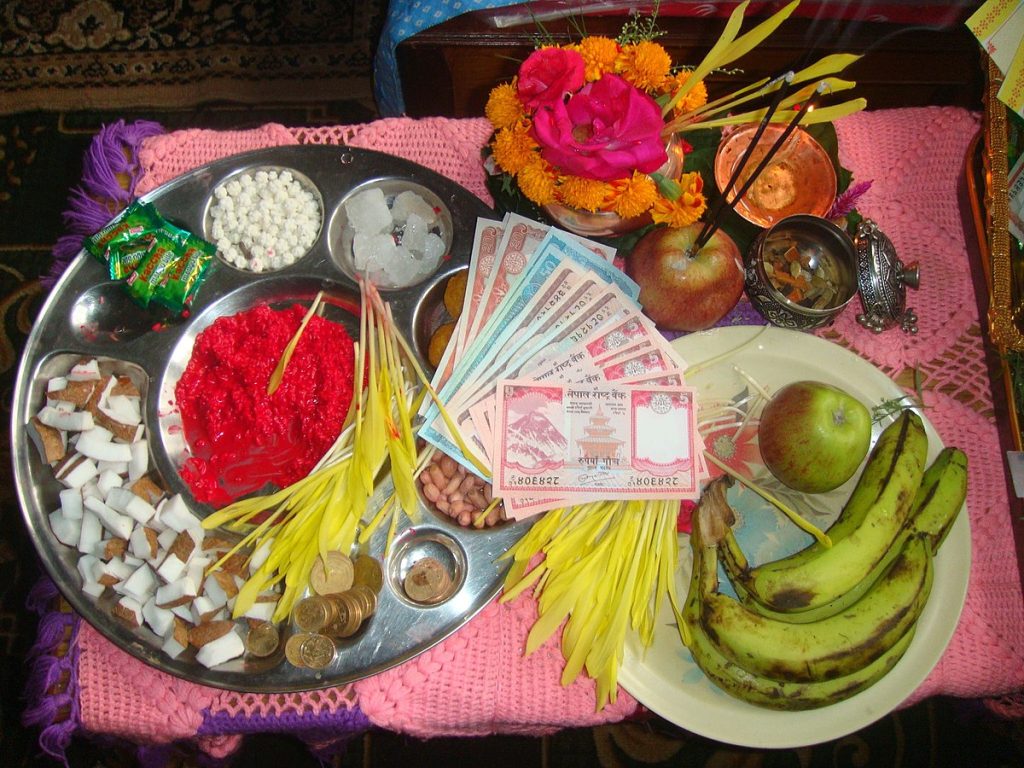 A plate full of Tika, Jamara, Fruits and Nepalese Rupees | Photo: Poonamkulung via Wikimedia Commons