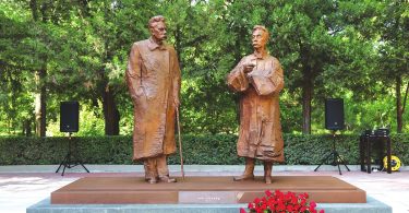 a statue of two men in a park